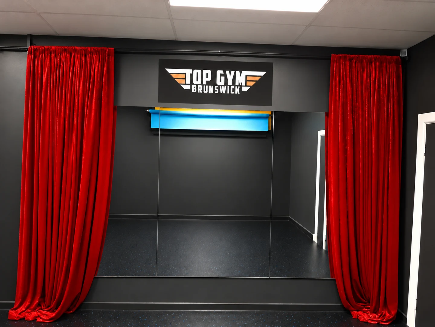 Large wall mirror with red curtains at Top Gym Brunswick photo studio — retouched photograph